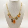 Collar de Eslabones Dorados con Dijes de Piedra Naranja, Pluma y Árbol de la Vida